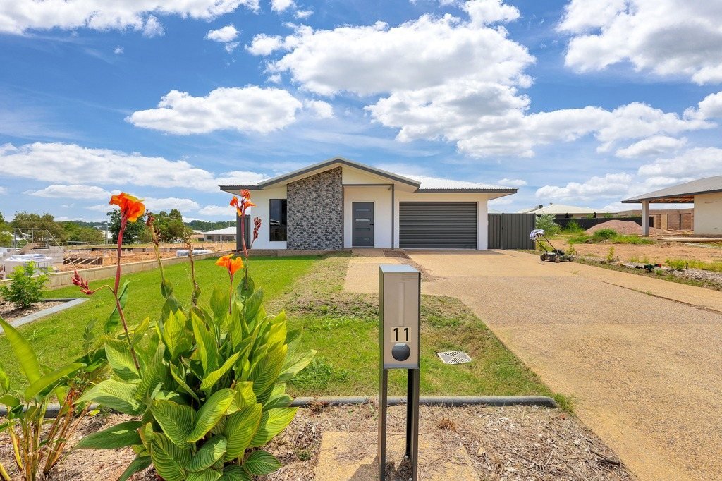 The front of 11 Turkeybush Way: a single-storey home with a stone feature wall, garage and front lawn.