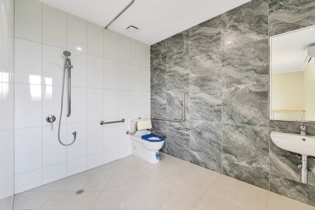 An accessible ensuite with a step-free shower and grab rails.