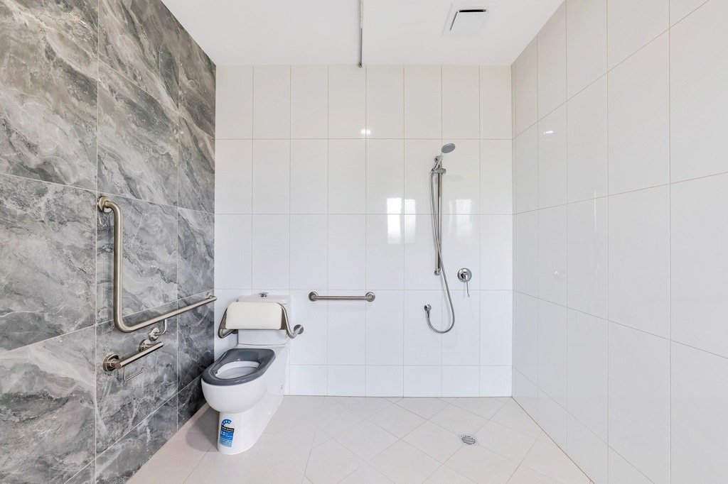An accessible ensuite with grab rails beside the toilet.