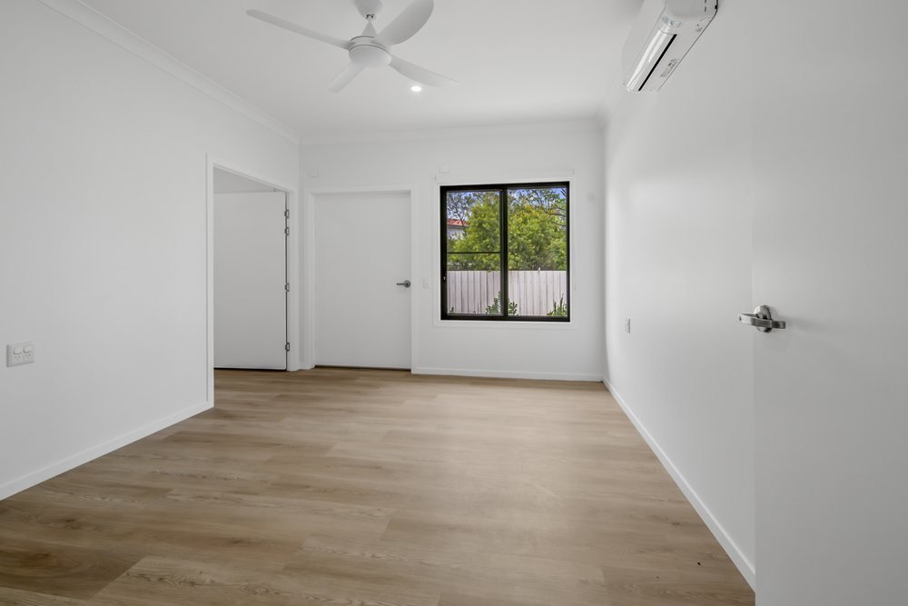 A bedroom with a built-in wardrobe and a window to the yard.