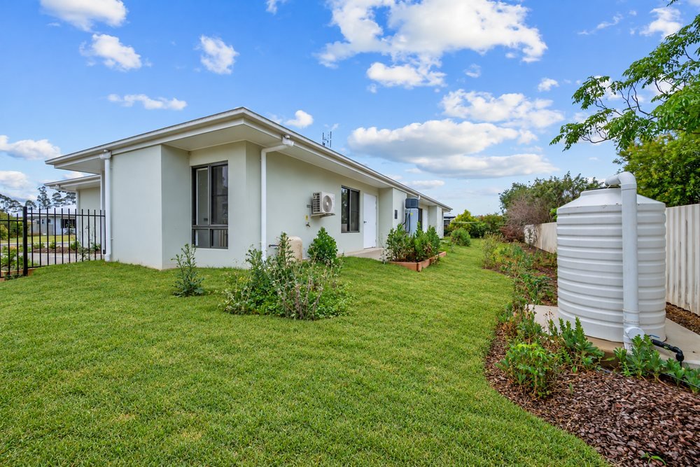 The back of the home and the covered alfresco, across the lawn.