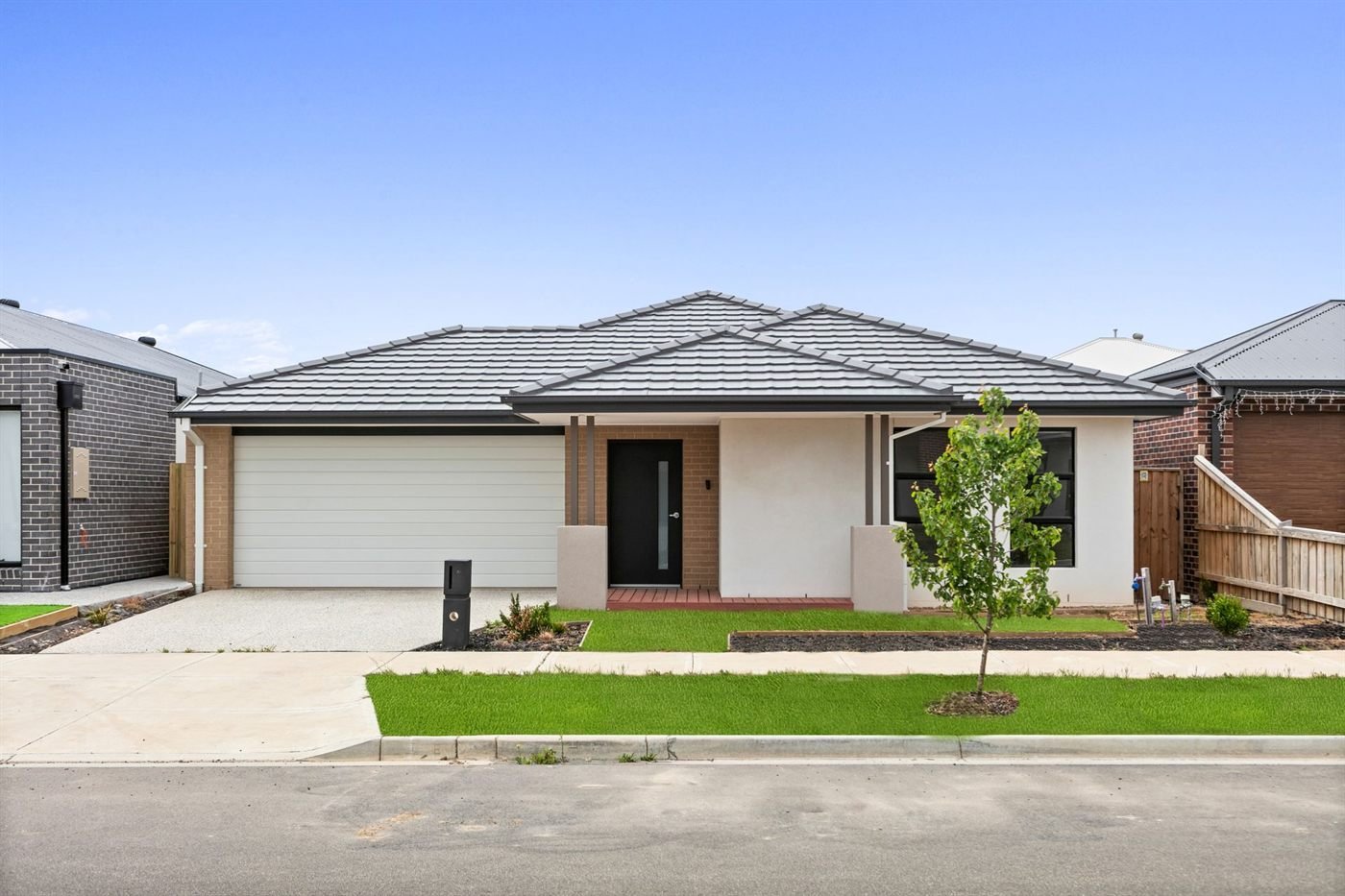 Street frontage of the Mickleham home: a single-storey brick residence with a double garage, driveway and lawn.