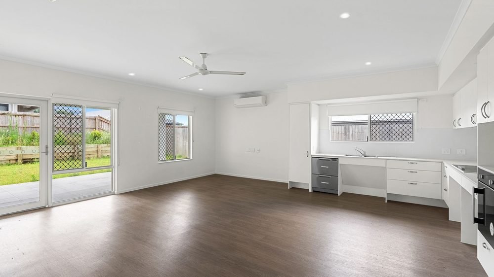 The open-plan living area, with the kitchen and a sliding door to the patio.