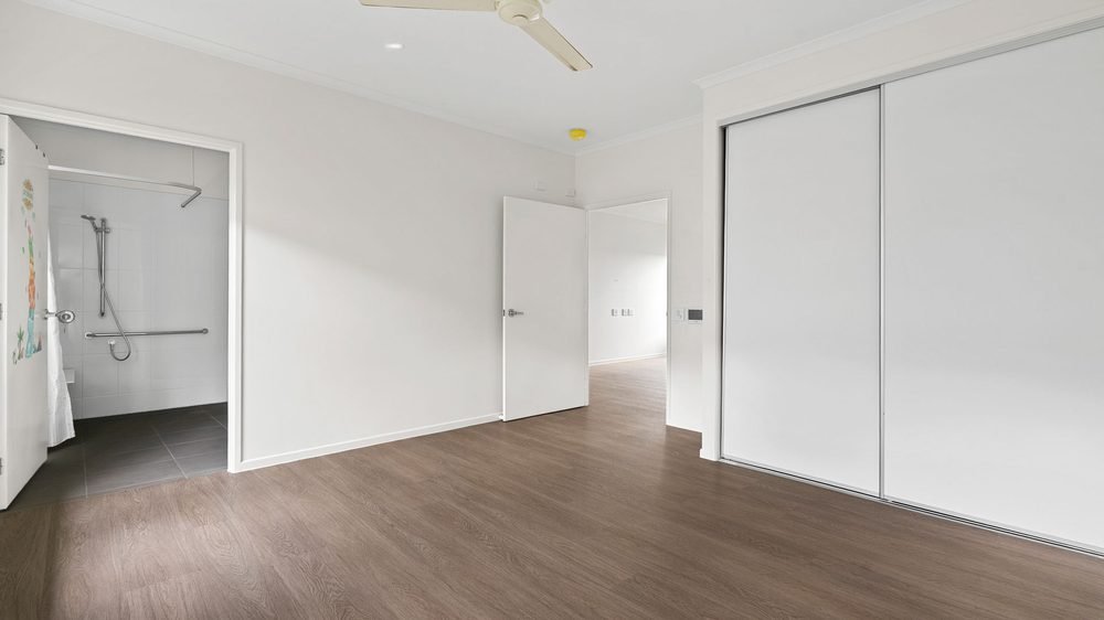 A participant bedroom with a built-in wardrobe and its own ensuite.
