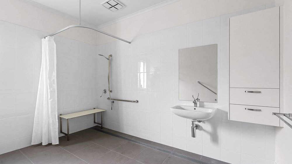 An accessible ensuite with a shower bench and step-free shower.